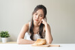 food intolerance concept, young women anxiety before eating bread worrying about gluten intolerance in the bread.