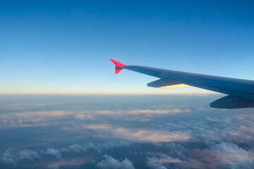 Wall Mural - Evening view from the aircraft cabin through the window on the wing and engine during the flight.