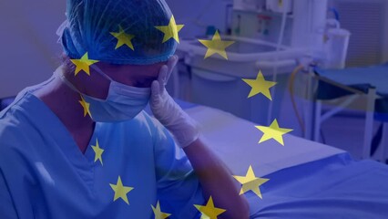 Poster - Animation of flag of europe over tired and sad caucasian female doctor joining hands in hospital