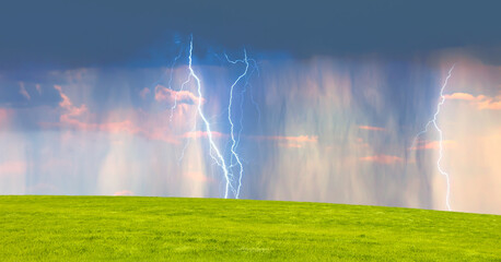 Wall Mural - lightning strikes between stormy clouds with green grass field