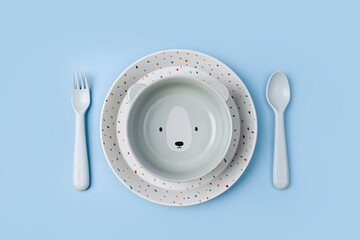 Cute children's plates and dishes shape of a bear. Creative serving for baby. Concept of kids menu, nutrition and feeding.