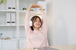 © mangpor2004 - Young asian woman with headphones stretching for relax after working