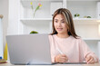 © mangpor2004 - Young asian woman writting on digital tablet while looking at laptop computer, online learning, work from home