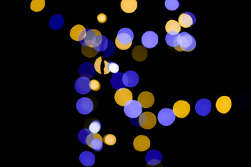 Blue and yellow festive bokeh lights on black background