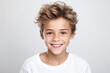 A close-up portrait photo of a charming young boy smiling, showcasing his clean teeth, designed for a dental advertisement. The boy features modern, stylish hair. Isolated on a white background.GenAI