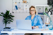 Portrait of 50's confident mature businesswoman, middle-aged experienced senior female professional working on laptop in cozy office work place. Female CEO, creative entrepreneur manage business.
