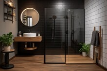 Basic bathroom with black shower, circular mirror, white tiles, and wood flooring.