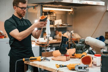 With drill. Technician working with prosthesis in modern laboratory