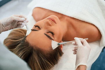 Wall Mural - Brushes are used to clean skin. Woman face getting facial care by beautician hands at spa salon