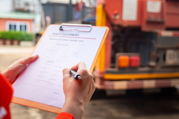 Wall Mural - a mechanical engineer is inspecting the condition of truck crane vehicle (as blurred background) bef