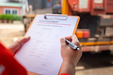 Wall Mural - a mechanical engineer is inspecting the condition of truck crane vehicle (as blurred background) bef