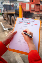 Wall Mural - a mechanical engineer is inspecting the condition of truck crane vehicle (as blurred background) bef