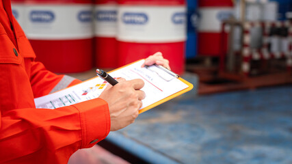 Wall Mural - a worker is checking on the hazardous chemical material information form with background of chemical