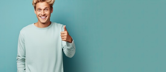 Wall Mural - Happy and satisfied young man casually pointing to empty space with a cheerful smile