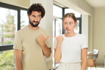 Canvas Print - young adult couple worried, feeling scared, frustrated and stressed