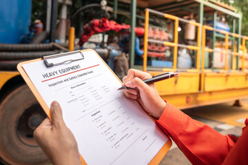 Wall Mural - A mechanical engineer is checking on heavy machine and equipment inspection checklist form with the water pumping unit as background . Heavy industrial working action scene, selective focus.
