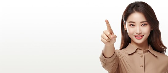 Poster - Happy young Asian woman in brown shirt pointing to empty space