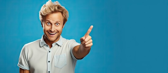 Poster - A cheerful and happy adult man with blond hair pointing upwards towards empty space