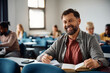 © Drazen - Happy mature man attending adult education training class in classroom and looking at camera.