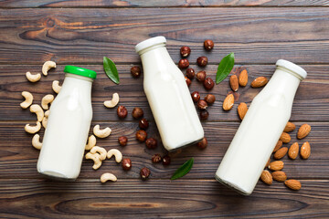 Set or collection of various vegan milk almond, cashew, on table background. Vegan plant based milk and ingredients, top view