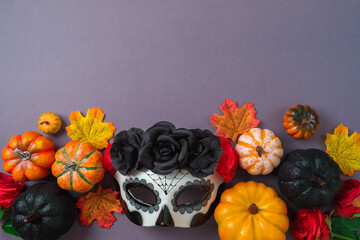 Wall Mural - Day of the dead Mexican and Halloween holiday concept. Sugar skull mask, pumpkin and party decorations on purple background. Top view, flat lay