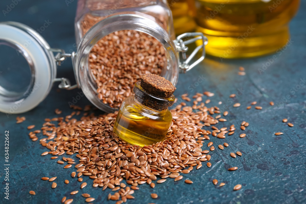 Jars with flax oil and seeds on blue background