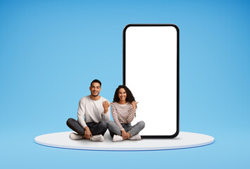 Wall Mural - Happy Young Arab Couple Pointing At Big Blank Smartphone With White Screen