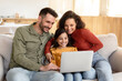 © Prostock-studio - Cheerful Parents And Daughter Using Laptop Spending Time At Home