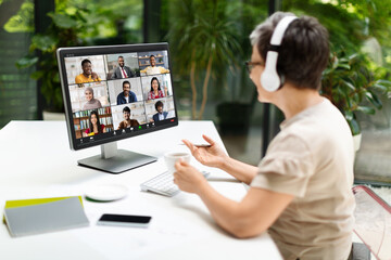 Wall Mural - Mature woman having video call via computer in home office