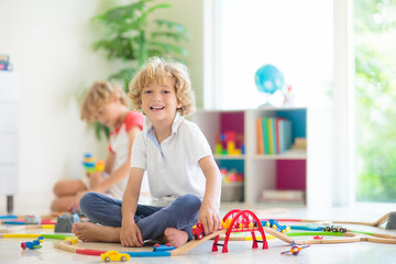 Child with toy train. Kids wooden railway.