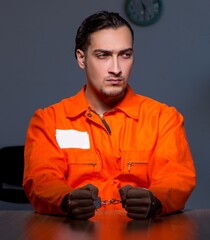 Poster - Young convict man sitting in dark room