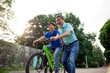 © Богдан Маліцький - asian old father and son ride bikes together in the park, korean senior and grandpa are active with child