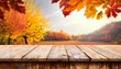 wooden table in front of a colorful autumn landscape, beautiful autumn background concept with fall leaves and advertising space