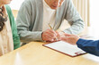 © taka - 契約書にサインをするシニア男性