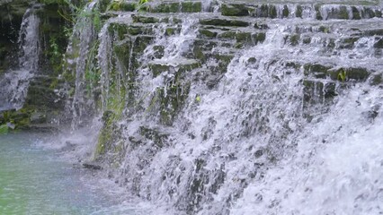 Wall Mural - waterfall in the forest with river water cascading down rocks in slow motion 