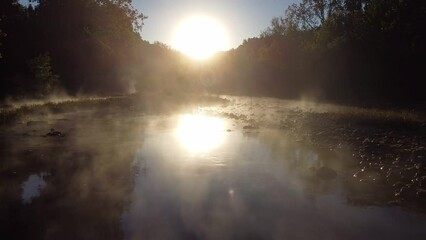 Wall Mural - Sun light through mist in the forest over foggy river with fog and misty rising over mountain river 