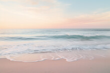 Morning breaks on a serene beach with the horizon painted in pastels offering an expansive sand canvas for designers