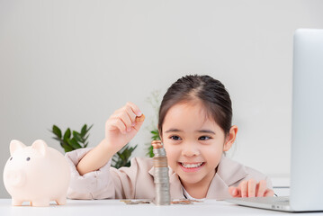 Asian little cute girl wearing a cream suit analyzing coins finance and investment