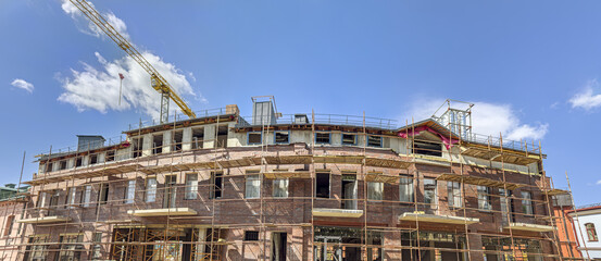 Wall Mural - old red brick building under renovation. panoramic view in sunny summer day.