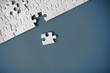 © alexkich - Clean puzzle elements on the red background. Empty puzzle piece on the table. Teamwork concept.