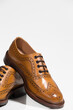Closeup of Pair of Tanned Brogue Derby Shoes Made of Calf Leather with Rubber Sole Isolated Over Pure White Background.