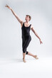 © danmorgan12 - Sports Ideas. Young Athletic Caucasian Ballet Dancer Man Posing in Stretching Pose With Hands Aligned and Knees Bended in Black Tights On White.