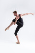 © danmorgan12 - Professional Male Ballet Dancer Man in Black Dance Suit Tights Posing in Ballanced Dance Pose While Stretching His Leg Muscles in Studio on White.