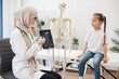 © sofiko14 - Pediatrician with MRI on tablet consulting girl in clinic