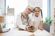 © sofiko14 - Woman in hijab and child posing near furry pet on vet visit