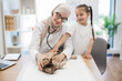 © sofiko14 - Animal doctor performing chest exam of cat with help of kid