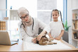 © sofiko14 - Muslim vet vaccinating cat near little girl in office