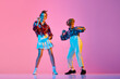 © master1305 - Stylish, emotional children in retro clothes dancing lindy hop against pink studio background in neon light. Concept of childhood, hobby, active lifestyle, performance, art, fashion