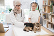 © sofiko14 - Vet and child brushing cat with gentle glove for shedding