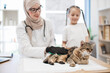 © sofiko14 - Vet and child brushing cat with gentle glove for shedding